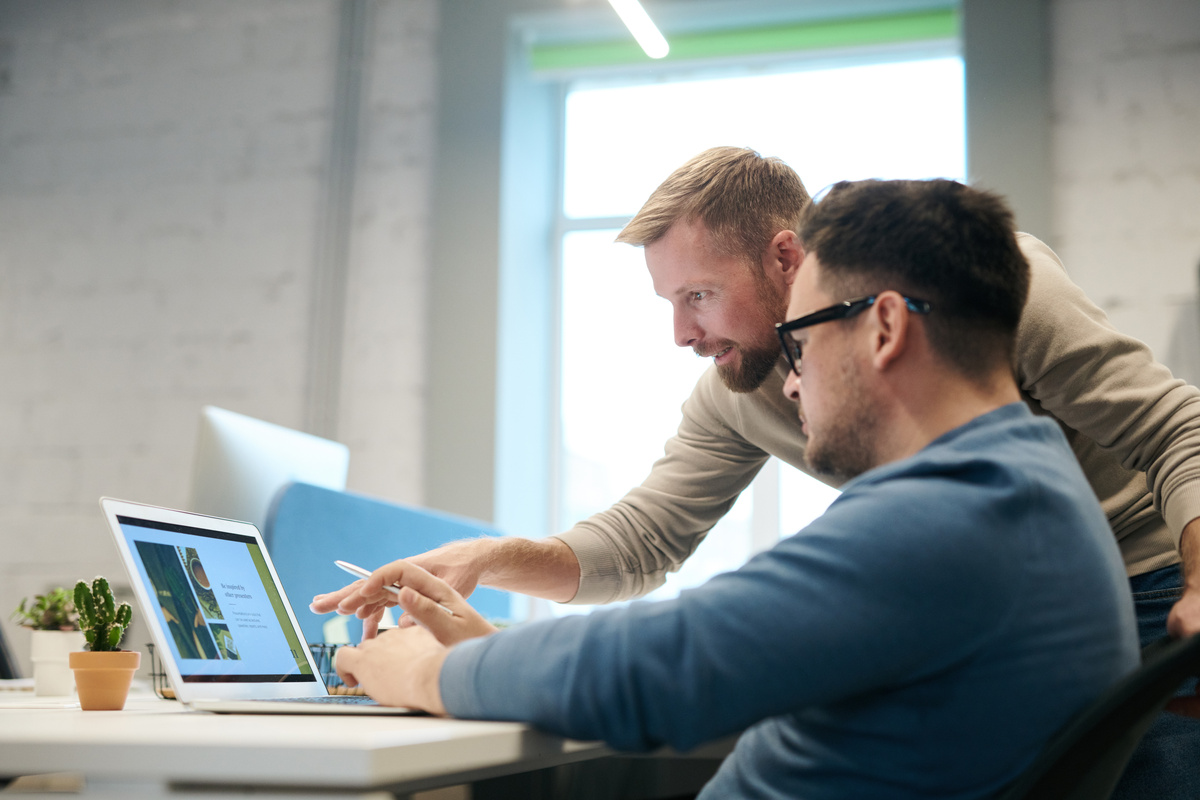 Two professionals collaborating on laptop